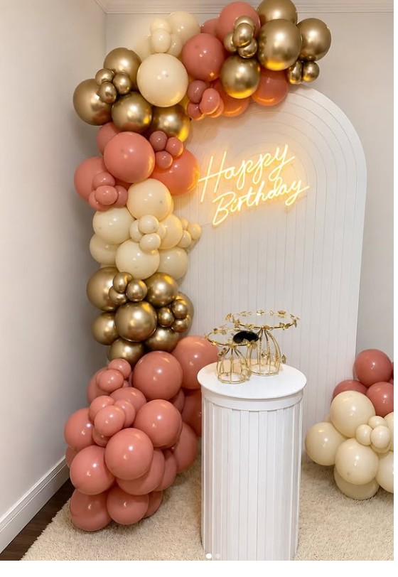 Arco de globos en tonos pastel rosado, crema y dorado