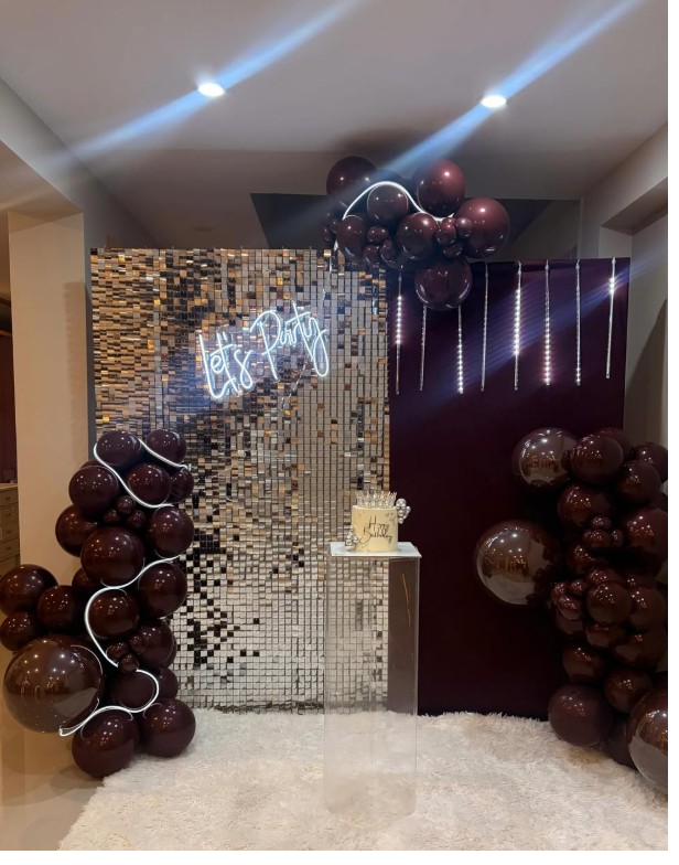 Decoración en negro y plata con letrero de neón Let's Party