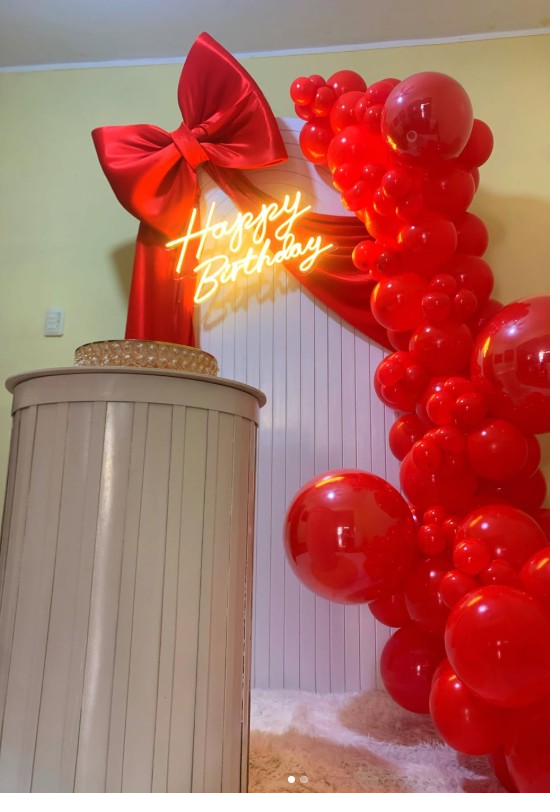 Backdrop con lazo rojo gigante y letrero de neón Happy Birthday